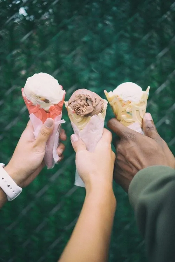 Trois mains tiennent chacune un cornet de glace